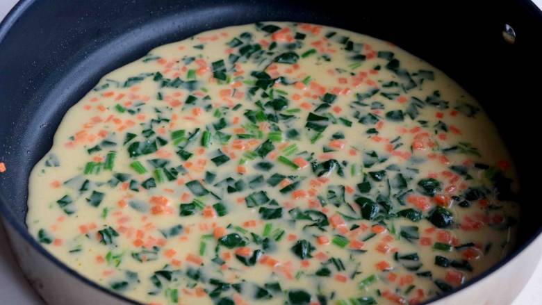 菠菜胡萝卜厚蛋烧,平底锅不粘锅刷一层薄薄的色拉油，倒入3/2鸡蛋液混合物，开小火盖上，待表面还有少于的蛋液未凝固；