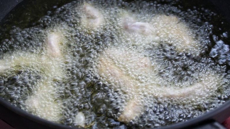 糖醋里脊,锅中放油烧至八成热，将肉条一条一条的放入锅中，用小火炸制