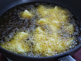 土豆烧茄子,另起锅倒入适量食用油烧至八成热，将土豆放入锅中改中小火炸制