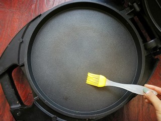 缤纷彩蔬洋葱蛋饼~,电饼铛预热，用油刷刷上薄薄的油，