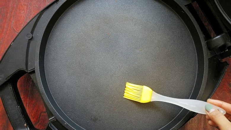 缤纷彩蔬洋葱蛋饼~,电饼铛预热，用油刷刷上薄薄的油，