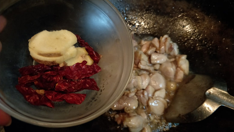 黄焖鸡--肉嫩汁浓拌米饭,倒入姜片和干辣椒。