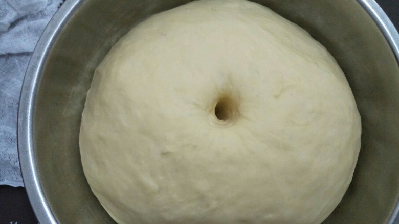 蔓越莓面包圈,面团发酵到原来的两倍大，手指沾点水在中间插个孔面团不回缩即发酵好。