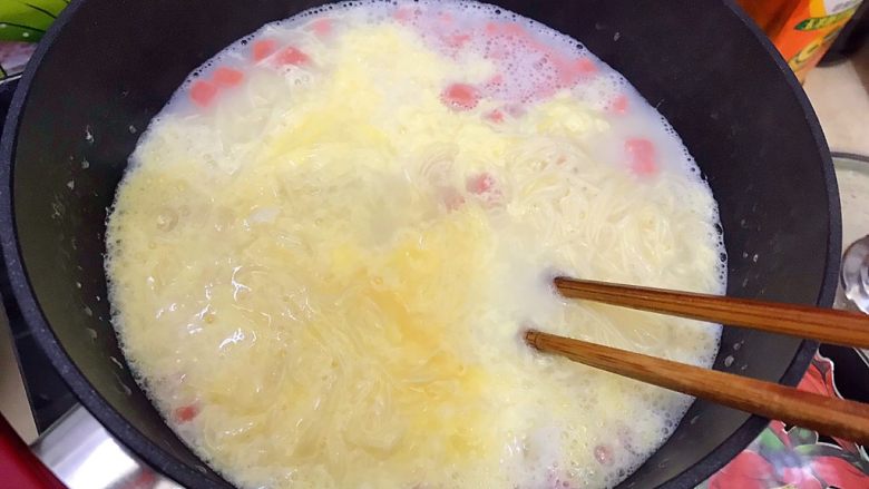 一碗面条+味蕾新体验之老干妈芝士火腿肠鸡蛋捞面,用筷子搅拌一下，使鸡蛋成絮状而不是块状