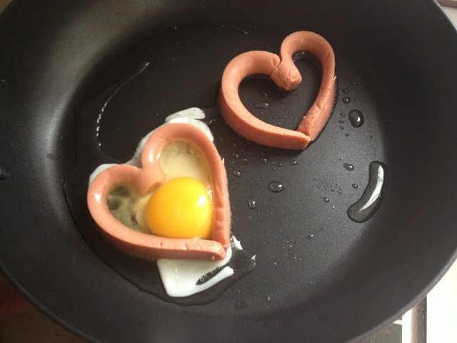 百变鸡蛋+爱心香肠煎蛋,先将蛋黄用勺子舀进爱心里，再用蛋清将空隙补上