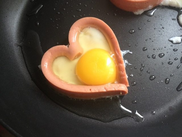 百变鸡蛋+爱心香肠煎蛋,香肠底不是固定的所以肯定会有蛋清留出来，边缘蛋白凝固后用勺子将多余的挂掉就OK拉~