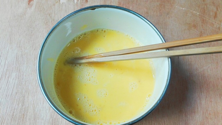 百变鸡蛋+枸杞花开海鲜菇鸡蛋,用筷子快速的顺时针划圆搅打蛋清蛋黄融合在一起