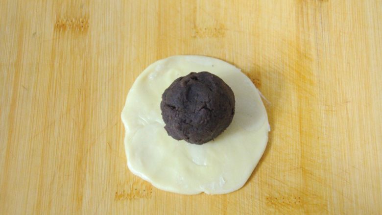 经典版蛋黄酥,取一个馅料，用擀好的酥皮把馅料包起来。