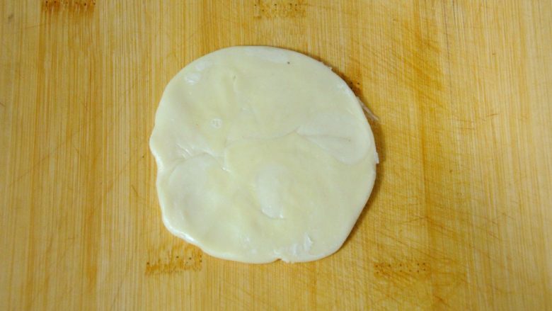 经典版蛋黄酥,上下左右各擀一下成片状，这个也很重要，千万不要像擀饺子皮一样使劲擀，那样的话也会造成破皮混酥。