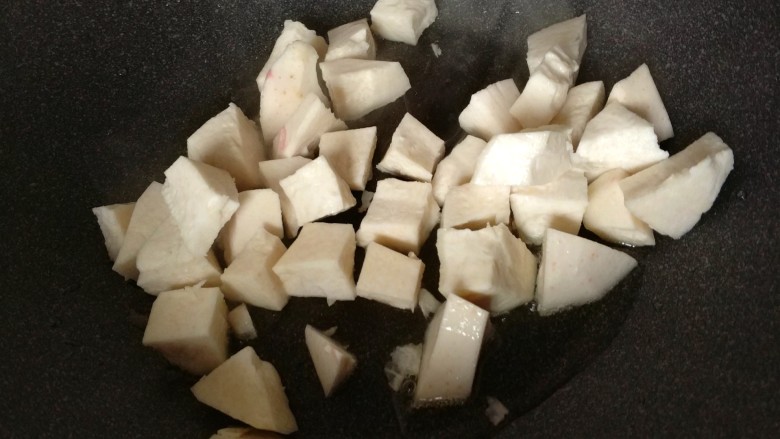 香菇腊肠芋头焖饭,热锅放油，先倒入芋头丁煎一下