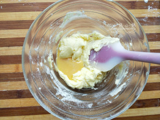 蔓越莓椰蓉卷--绵软香甜,分次加入打散的蛋液拌匀，蛋液量比较大，要等上一次的蛋液吸收完再加下一次的蛋液。