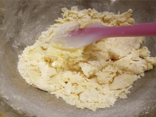 黄油小圆饼,用硅胶铲从底部往上翻拌，碾压，呈现如图块状