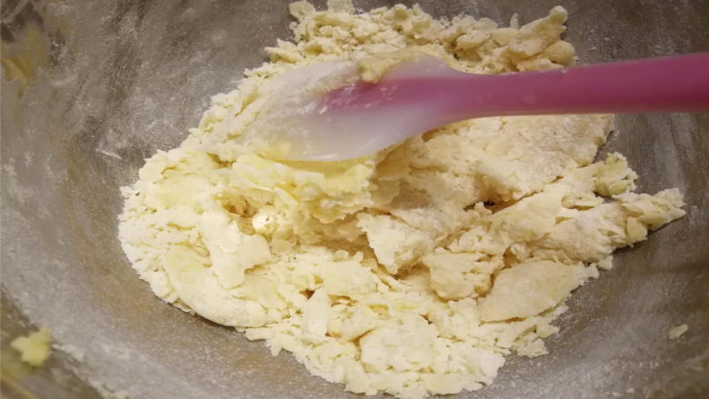 黄油小圆饼,用硅胶铲从底部往上翻拌，碾压，呈现如图块状