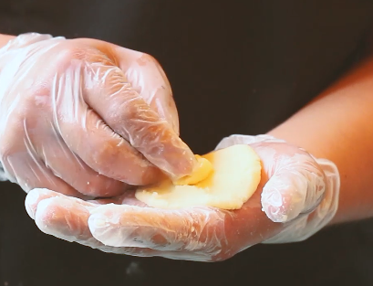 土豆芝士球,揉成面团，取适量面团在手心压成饼状，中间放上芝士。