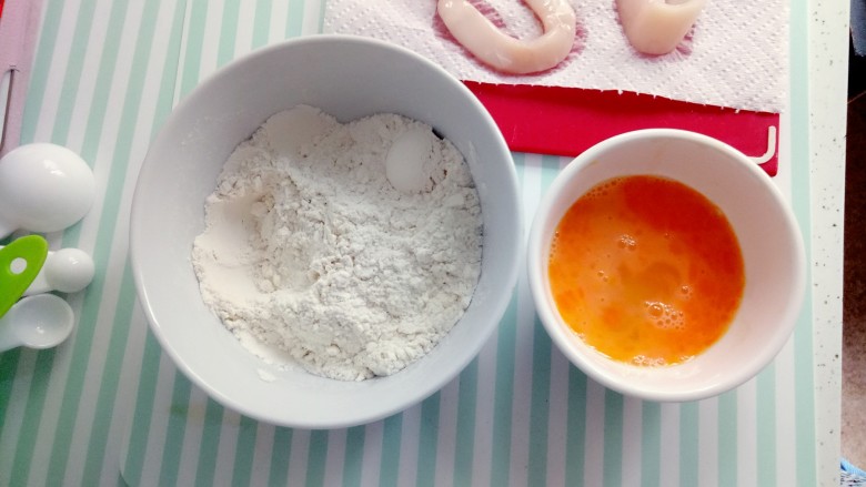 东南亚特色--麦片鱿鱼,准备好一碗中粉，中粉中加入盐巴3g+胡椒粉2-3g,再准备打好的鸡蛋。先把吸干水份的鱿鱼放中粉中搅拌均匀再放入鸡蛋中上浆。