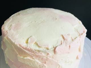 6寸双色蛋糕,从白色奶油中，分出一部分奶油，加入粉色色素，在已经抹好白奶油底的蛋糕上，取少量粉色用抹刀，一小部分一小部分的涂抹。
