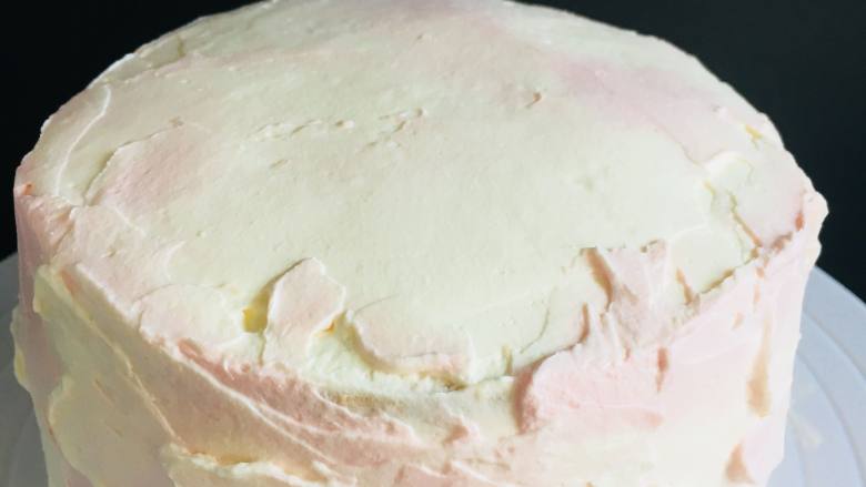 6寸双色蛋糕,从白色奶油中，分出一部分奶油，加入粉色色素，在已经抹好白奶油底的蛋糕上，取少量粉色用抹刀，一小部分一小部分的涂抹。