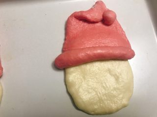 圣诞老人面包,帽子上面尖的部分折过来一块，下面圆的部分卷起来，当作圣诞老人的帽子，再和脸这两块组装起来