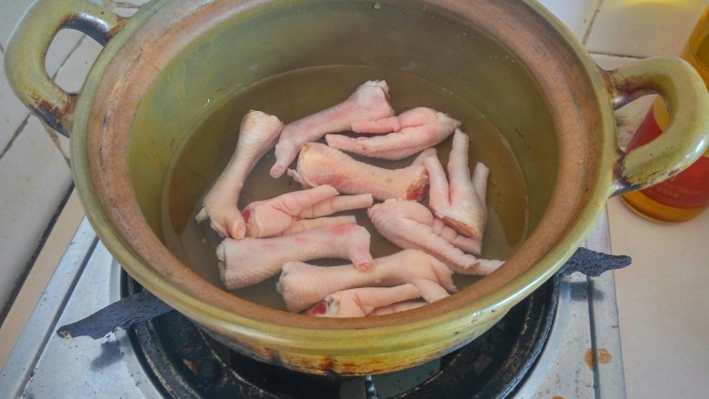 花生鸡脚汤,瓦煲清洗干净、加入清水、放鸡脚煮5分钟（焯水）