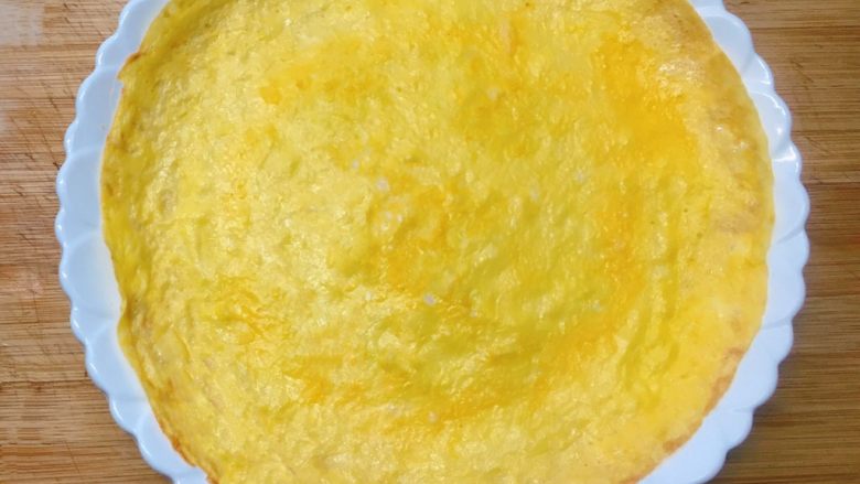 百变鸡蛋+蛋包饭,将煎好的蛋饼皮平铺放入盘中。