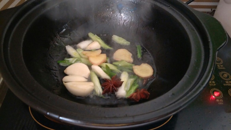 土豆烧排骨,油热后下入葱姜蒜、八角炒香