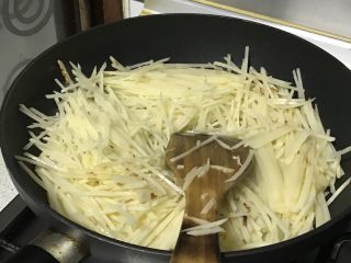 家常小炒—酸辣土豆丝,倒入沥干水分的土豆丝，迅速翻炒。