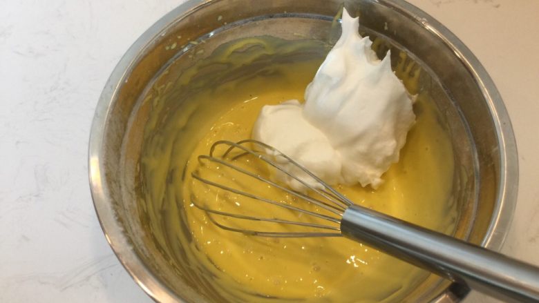 徒手打发戚风蛋糕,取1/3的蛋白霜与蛋黄糊中，用蛋抽翻拌均匀，手法类似于切半，从中轴切下，紧贴盆壁划过，同时用手转动打蛋盆。
