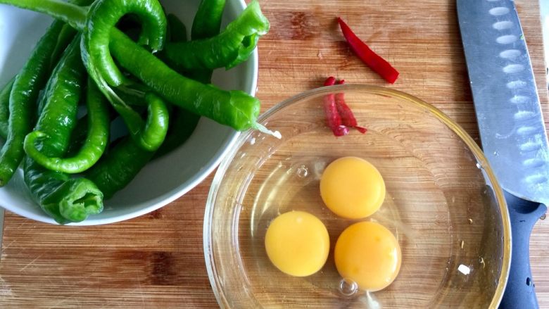 夹馍馍菜之线椒炒蛋,线椒去蒂去籽后清洗备用，小米椒去蒂清洗，鸡蛋磕入深碗中