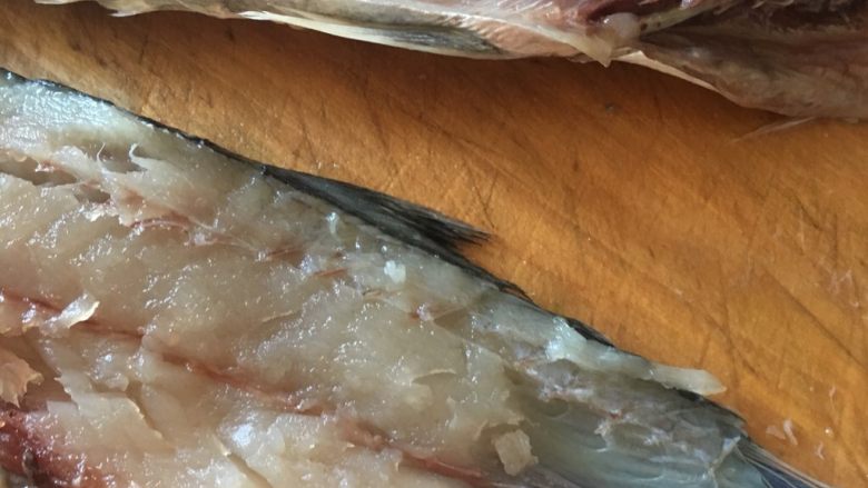 鲅鱼饺子,将鱼肉用小勺自鱼皮上面刮下。