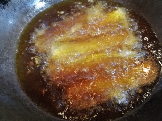 外酥里嫩~炸带鱼,锅内添油，油温90度时放入鱼段炸制。