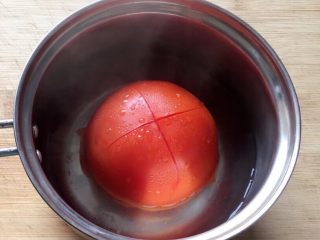 百变鸡蛋+番茄炒蛋,先将番茄用刀划划十字，放入开水中烫一下。