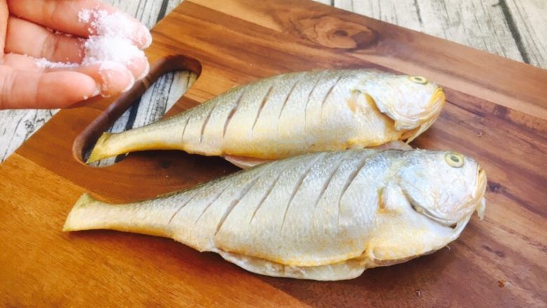 肉末雪菜蒸黄鱼,在鱼的两面和内脏抹上少许的盐，腌制10分钟。
