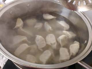 东北酸菜猪肉水饺,放入已经翻开的水中，煮，煮个10分钟左右就可以啦