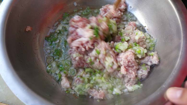 东北酸菜猪肉水饺,肉放在盆里加葱花，油烧热倒进去