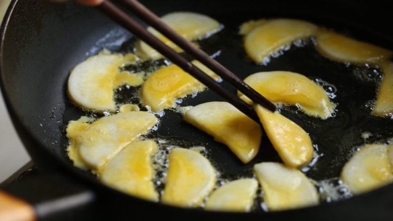蛋黄煎杏鲍菇,将杏鲍菇片摒去多余蛋糊后放入锅内煎。中小火煎至一面金黄微卷时，翻面也煎至金黄。