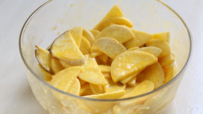 蛋黄煎杏鲍菇,将切好的杏鲍菇片全部浸入蛋糊中，搅拌使其均匀裹上薄薄的一层蛋糊。