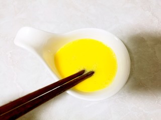 酒酿桂花粉红鸡蛋丸子,另取一碗，打入一个鸡蛋，用筷子搅打均匀。