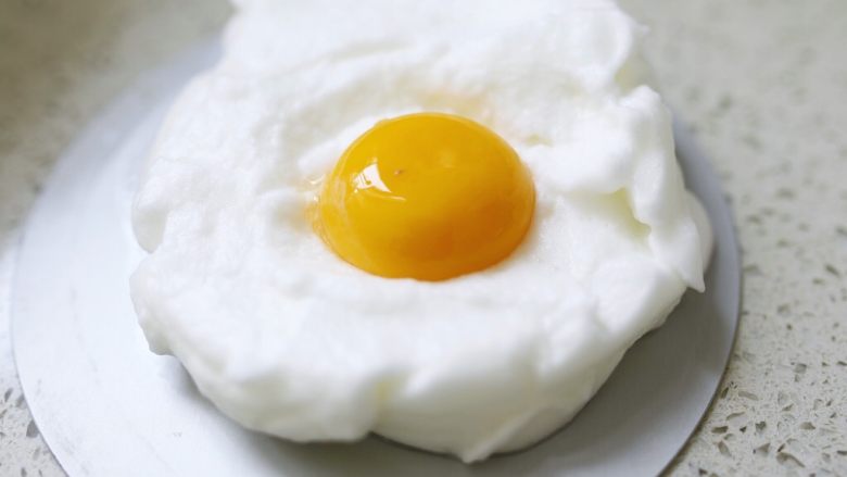 云朵蛋吐司,用勺子把蛋白霜铺在烤盘上，修整出圆圆厚厚的☁️形状，然后把蛋黄倒在☁️中间。烤箱190度，烤6分钟。
