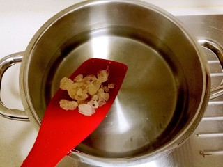 酒酿桂花粉红鸡蛋丸子,锅里的水煮开后，放入冰糖。