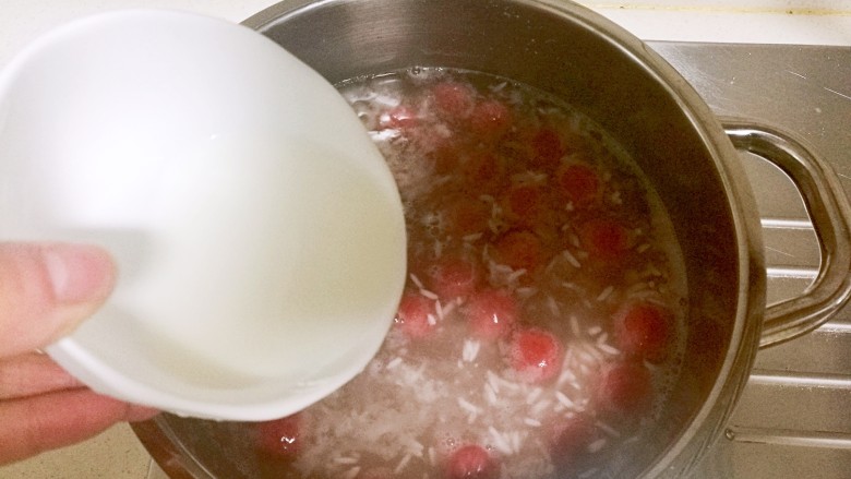 酒酿桂花粉红鸡蛋丸子,冒小泡后倒入淀粉水开始勾芡，勾入薄薄一层淀粉水。