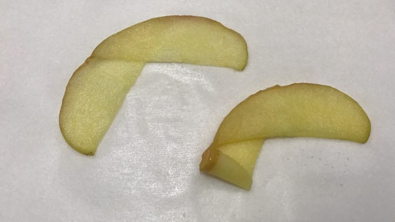 芝士苹果派,拿两片苹果片首尾重叠，从一边慢慢卷起，卷成一个小花。