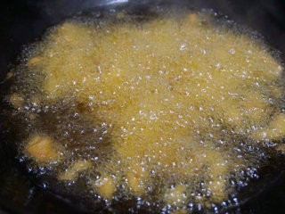 宫保鸡丁,锅内倒油烧热，然后将腌制的鸡丁放入油锅中快速滑油至表面金黄即可捞出
