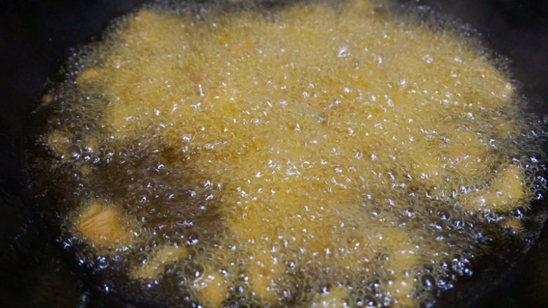 宫保鸡丁,锅内倒油烧热，然后将腌制的鸡丁放入油锅中快速滑油至表面金黄即可捞出