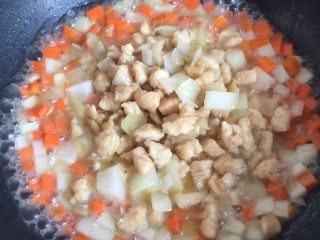 咖喱鸡肉饭,当胡萝卜和土豆丁煮到可以吃了时放入炒好的鸡肉丁