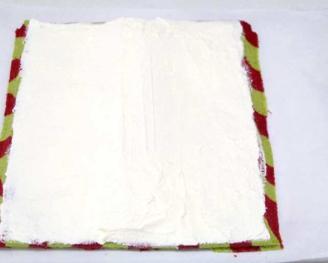 漂亮的圣诞蛋糕卷,晾凉的蛋糕再倒扣~左右两边先斜45度角切掉一点~然后均匀抹上淡奶油，中间厚，两边薄~