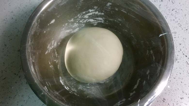 小兔子香肠馒头卷,把面团放入不锈钢盆里，盖上保鲜膜，放在温暖处进行第一次发酵。