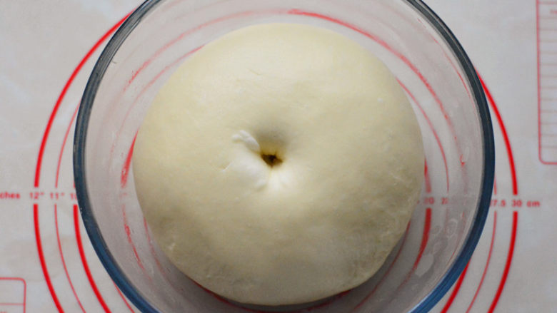蔓越莓小餐包,把揉好的面团放入大碗中，盖保鲜膜进行基础发酵，发酵好的面团，在表面戳一个洞，不回缩、不踏陷。
