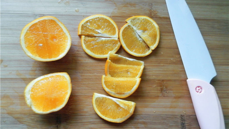 橙香费南雪,用锋利、抗氧化的奈瓷刀将橙子对半切开，中间漂亮的部分切4片，再将4片对半切。