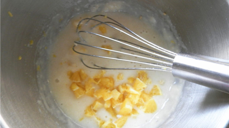 橙香费南雪,橙香果粒倒入面糊中，搅拌均匀。