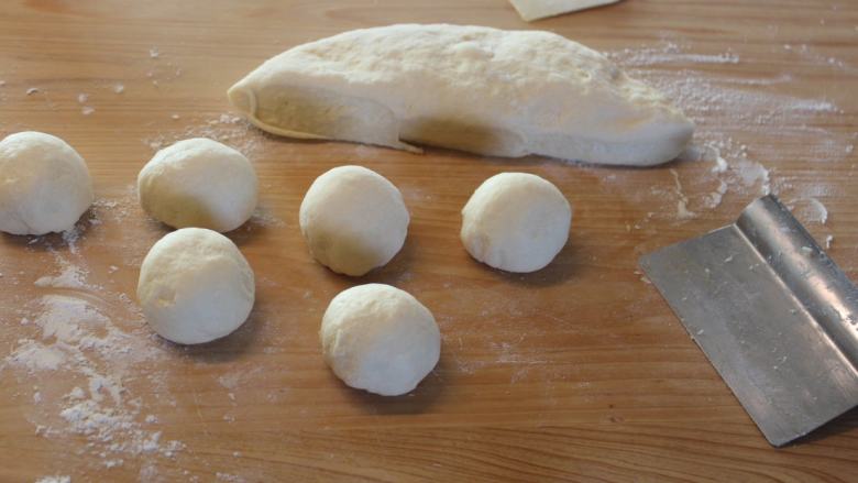 塞尔维亚螺旋面包,将面团压平，分割成60g左右的小面团，覆盖静置30分钟。